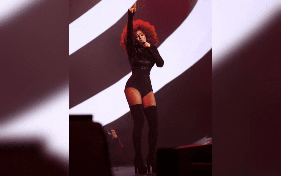 Співачка в чорному боді та з неординарною зачіскою на голові