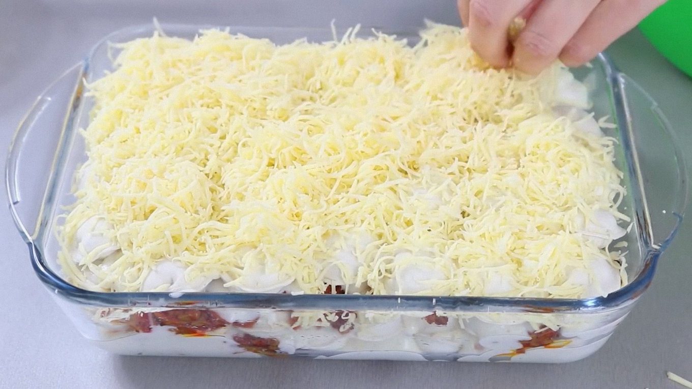 Перед духовкою закрийте начинку соусом та щедрим шаром сиру