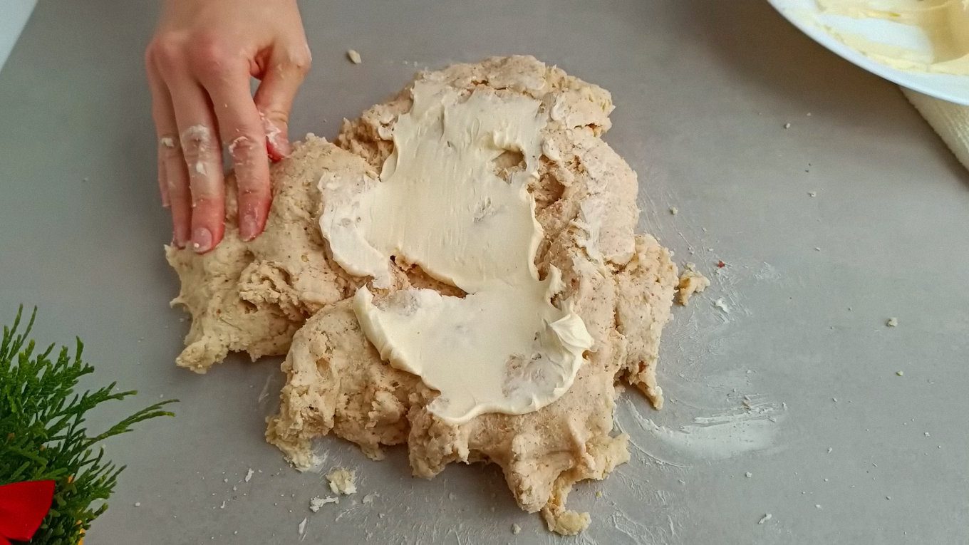 Поетапно вимішуємо масло, щоб тісто стало гладким та еластичним